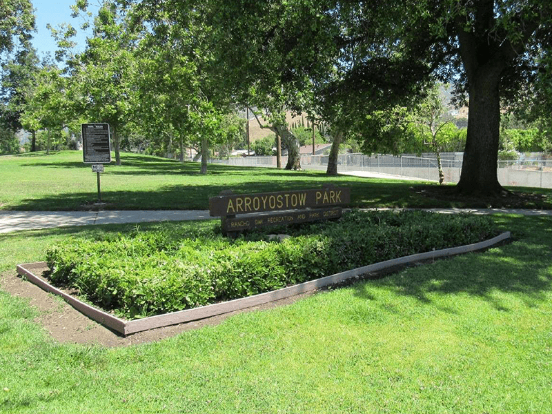 Arroyostow Park sign with grass and trees