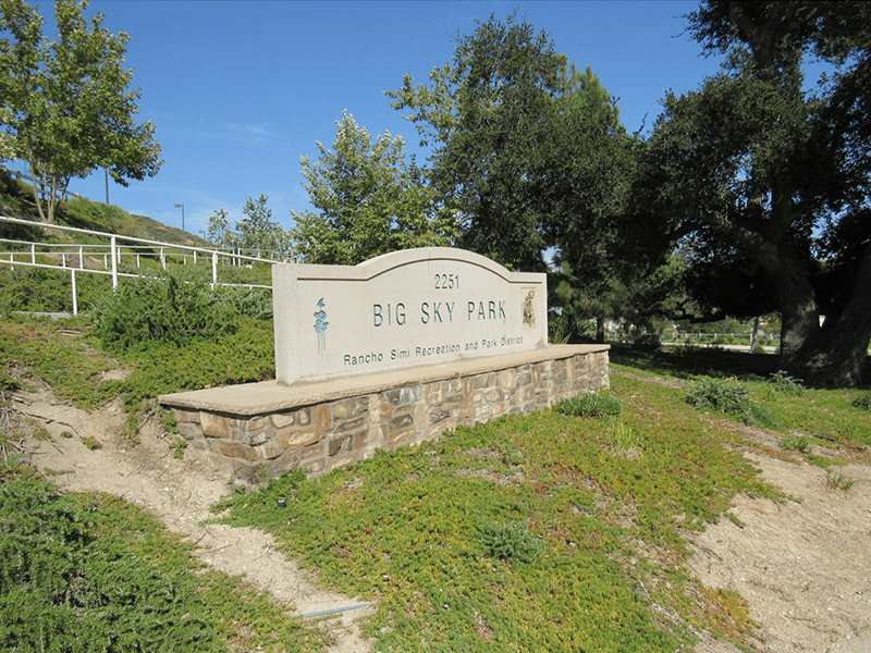 Big Sky Park sign with grass and trees