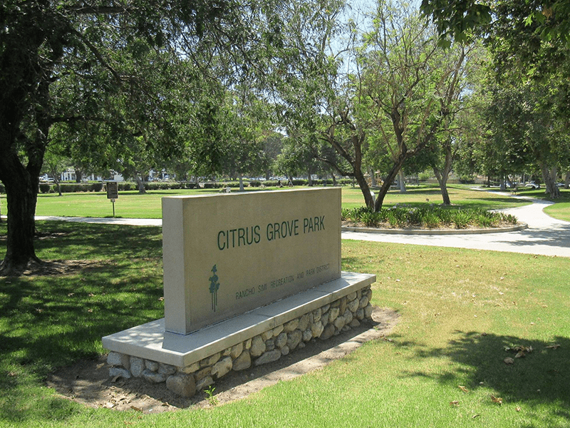 Citrus Grove Park sign with grass fields and trees around it