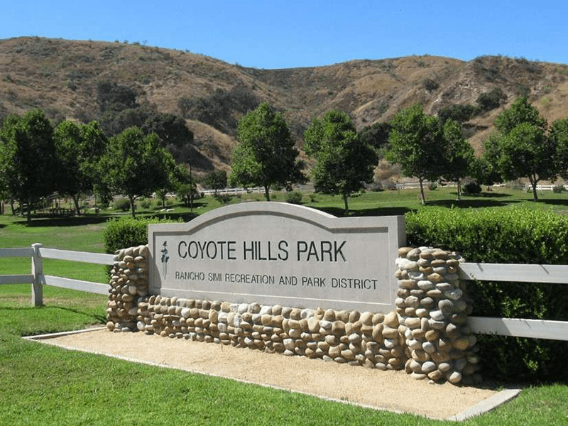 Coyote Hills Park sign with a grassy field and trees