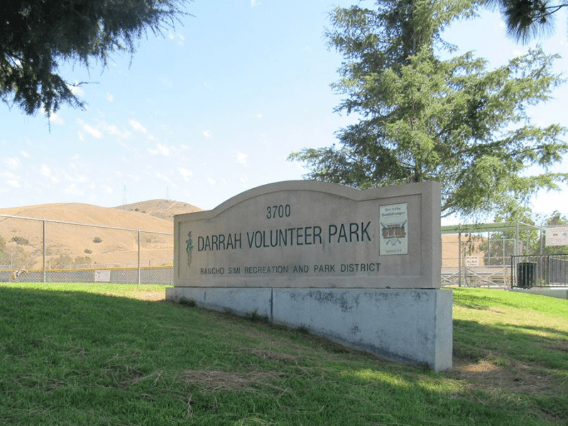 Darrah Volunteer Park sign with grass and hills in the background