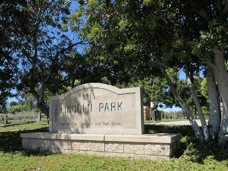 Lincoln Park sign with trees and grass