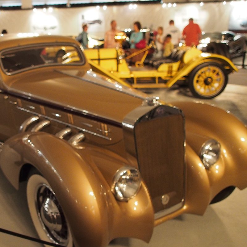 A gold car on display.