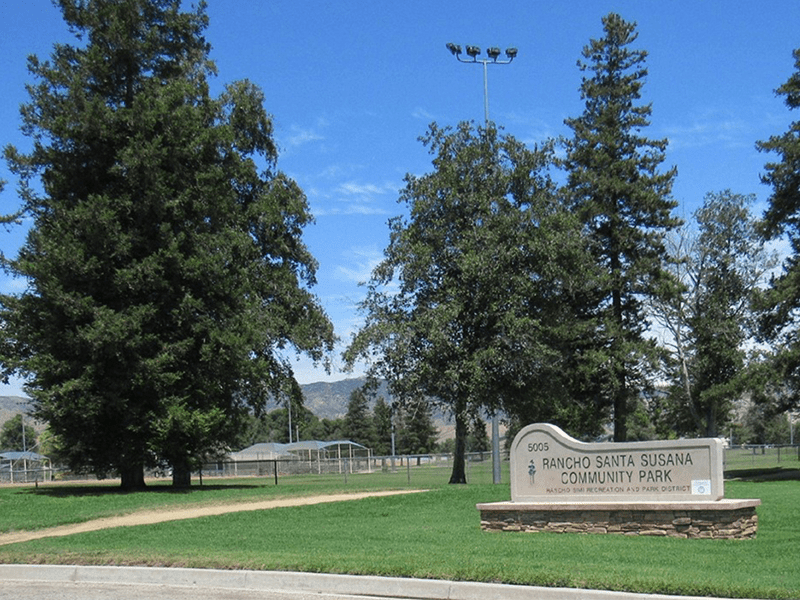 Rancho Santa Susana Community Park sign with trees and a grass field