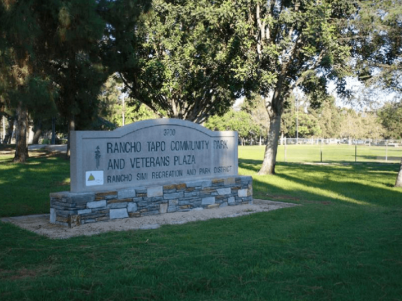 Rancho Tapo Community Park sign in a shaded grass area with trees