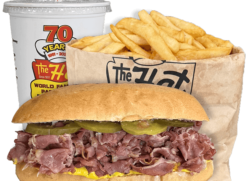 A roast beef sandwich with pickles and mustard, a serving of French fries in a paper bag, and a large soft drink in a branded cup.