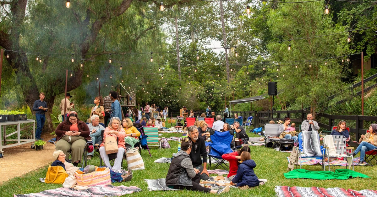 A lively outdoor gathering in Simi Valley with families and friends enjoying a picnic and music.