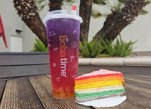 Colorful rainbow crepe cake with layered rainbow drink in Simi Valley outdoor setting.