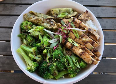 Healthy grilled chicken and broccoli salad with fresh greens and vegetables.