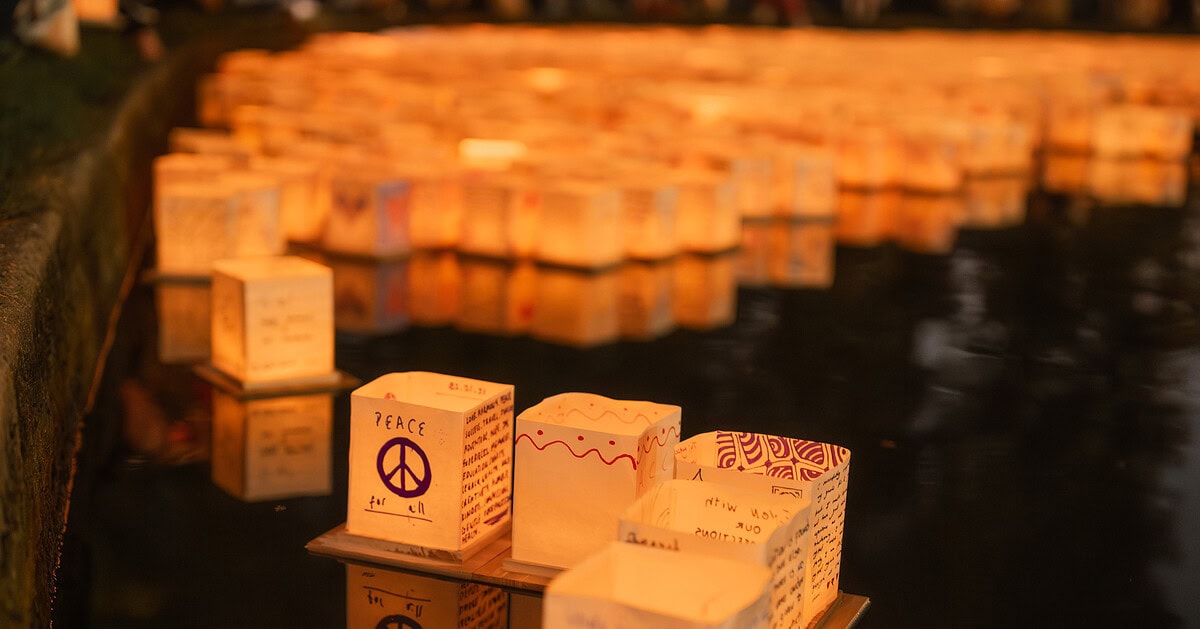 Lanterns floating on water during Simi Valley Water Lantern Festival at night.