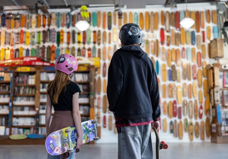 Two people standing in front of a skateboard shop.